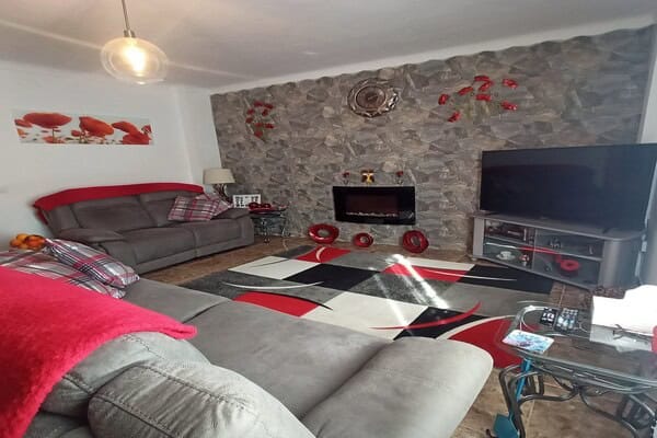 Cozy living room with modern furnishings and stone wall in Hinojares village property.