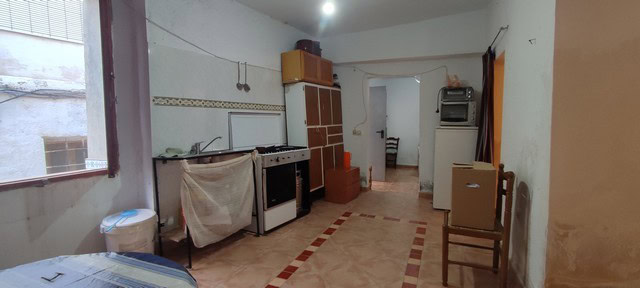 Interior view of a rustic village home in Seron, Almeria, showing a simple kitchen and living area.