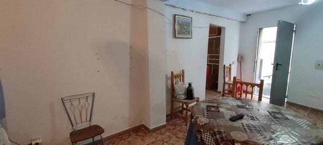Interior view of a village house in Seron, Almeria, showing a simple living space with wooden furnit.