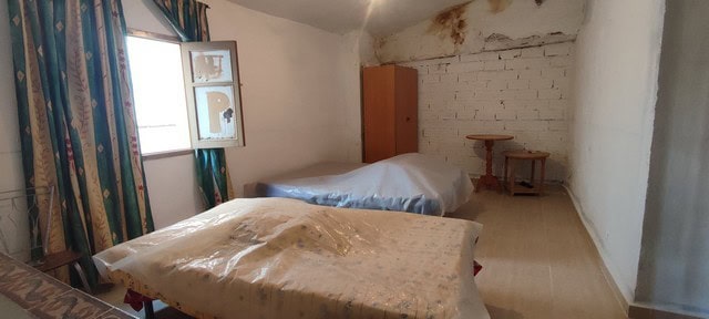 Interior view of a rustic village property in Seron, Almeria, showing simple bedrooms with basic fur.