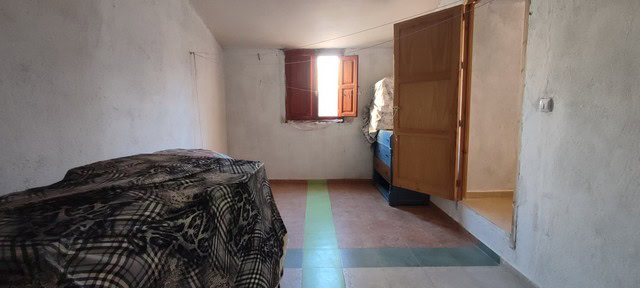 Interior view of a rustic village house in Seron, Almeria, showing simple furnishings and a small wi.