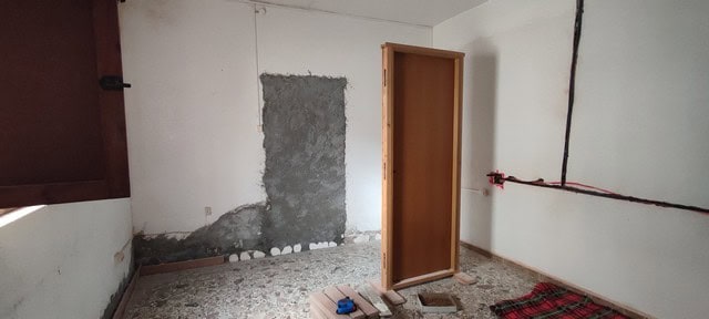Interior view of a rustic village property in Armuna, Almeria, showing unfinished walls and flooring.