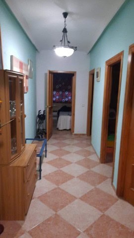 Hallway view inside a villa in Fines, Almeria, showcasing wooden door frames and a ceiling light fix.