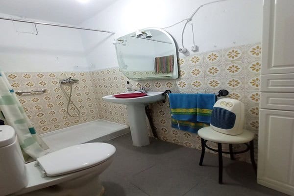 Cozy bathroom in rural property in Don Pedro, Jaen with shower, toilet, and mirror.