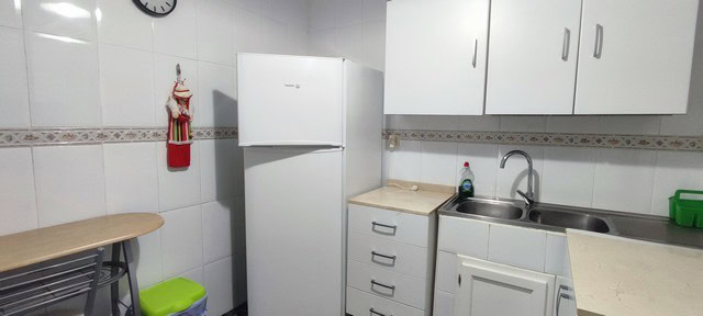 Compact kitchen with white appliances and cabinets in Tijola, Almeria.