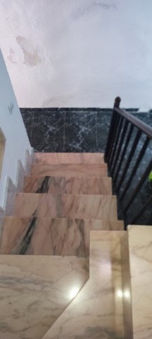 Charming town house staircase in Tijola, Almeria, with marble steps and black railing.