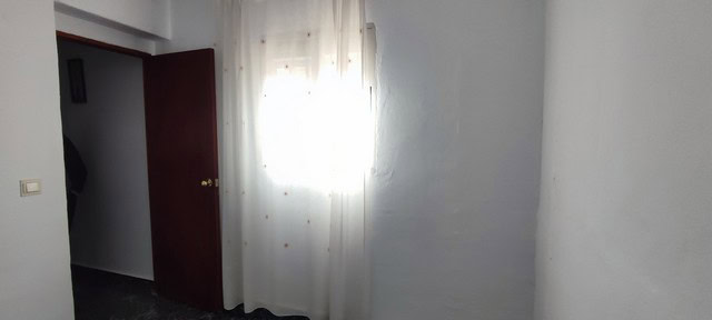 Interior view of a town house in Tijola, Almeria, showing a bright room with a window and white wall.