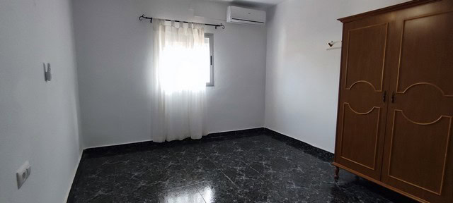 Interior view of a spacious town house room in Tijola, Almeria, with white walls, a window with curt.