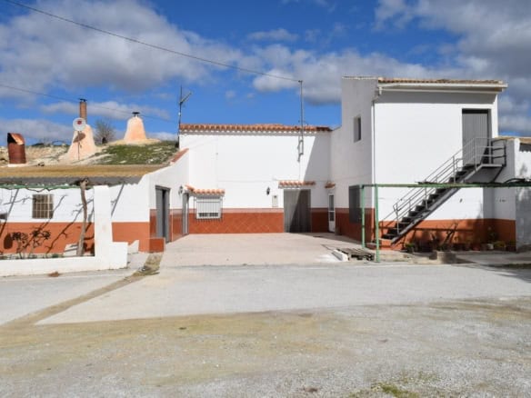 Cave house in Cuevas del Campo, Granada, with whitewashed walls and traditional architecture.