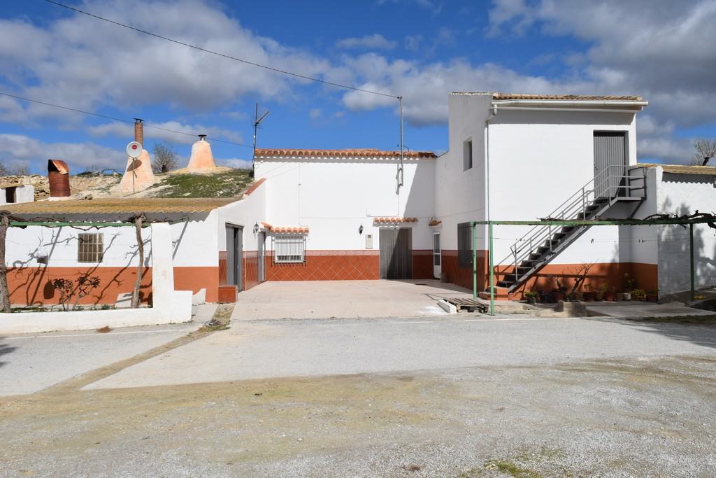 Cave house in Cuevas del Campo, Granada, with whitewashed walls and traditional architecture.