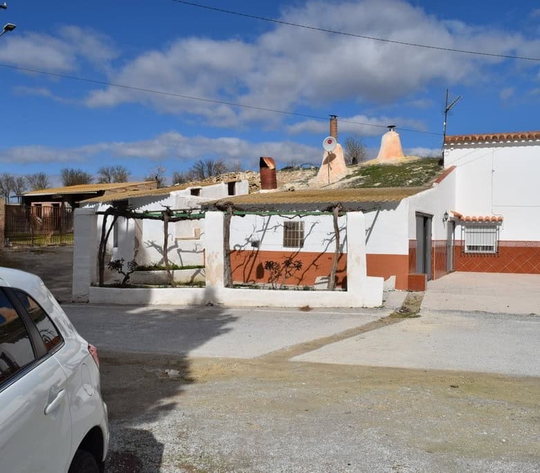 Traditional cave house in Cuevas del Campo, Granada, with rustic exterior and unique underground arc.