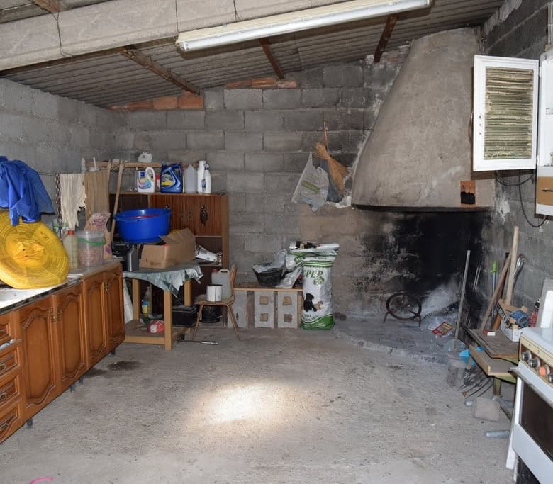 Interior of a rustic cave house kitchen in Cuevas del Campo, Granada, showing basic furnishings and.