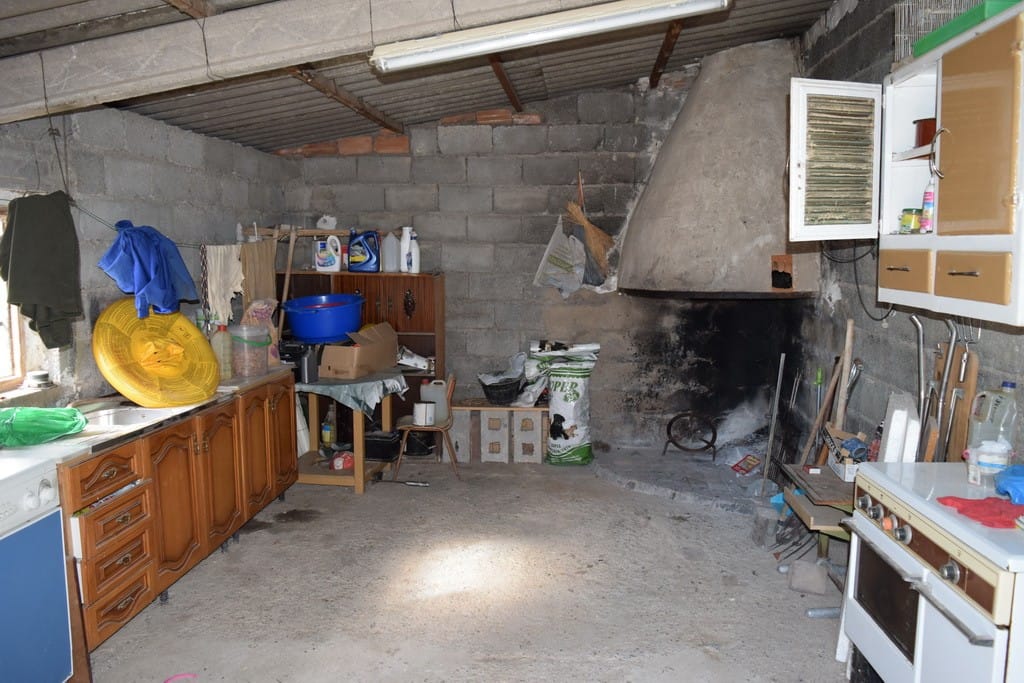 Interior of a rustic cave house kitchen in Cuevas del Campo, Granada, showing basic furnishings and.