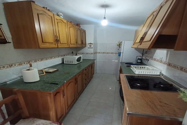 Rural property kitchen in Don Pedro, Jaen with wooden cabinets and modern appliances. Perfect for a.
