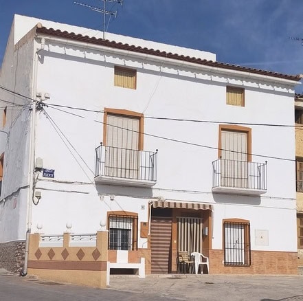 Charming village house in Benamaurel, Granada, featuring a white facade, small balconies, and tradit.