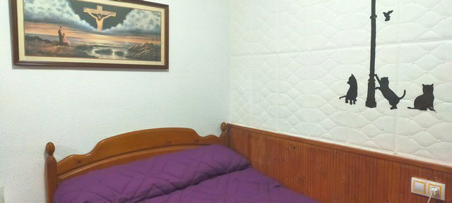 Cozy bedroom with purple bedding and wall art in Benamaurel village, Granada.