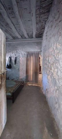 Interior view of a rustic rural property in Seron, Almeria, showcasing stone walls and wooden ceilin.