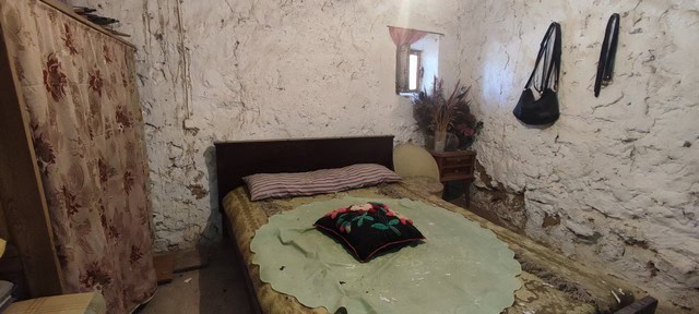 Charming rustic bedroom in Seron, Almeria with stone walls and simple furnishings.