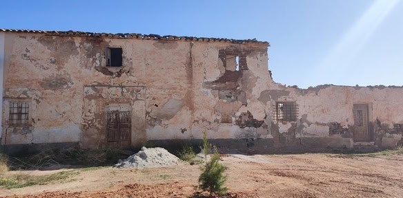 Abandoned stone ruin in Rejano, Granada, showcasing historic architecture and scenic rural surroundi.