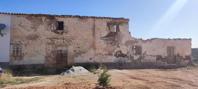 Abandoned stone ruin in Rejano, Granada, showcasing historic architecture and scenic rural surroundi.