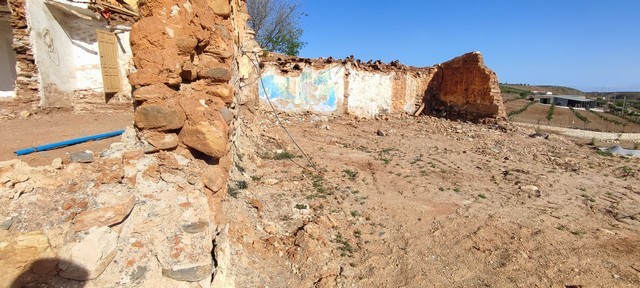 Ruin in Rejano, Granada with crumbling walls and open landscape.