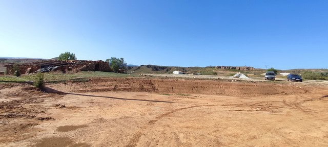 Ruin in Rejano, Granada with open land and clear blue sky.