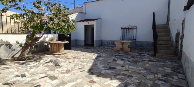Cave house with outdoor patio in Caniles, Granada, featuring stone flooring and traditional architec.