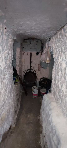 Interior view of a traditional cave house in Caniles, Granada, showcasing rustic stone walls and coz.