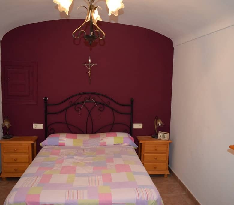 Unique cave house interior in Gorafe, Granada with cozy bedroom and rustic decor.