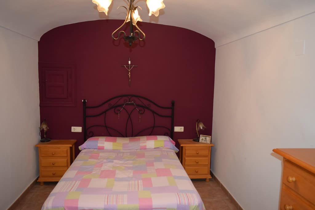 Unique cave house interior in Gorafe, Granada with cozy bedroom and rustic decor.