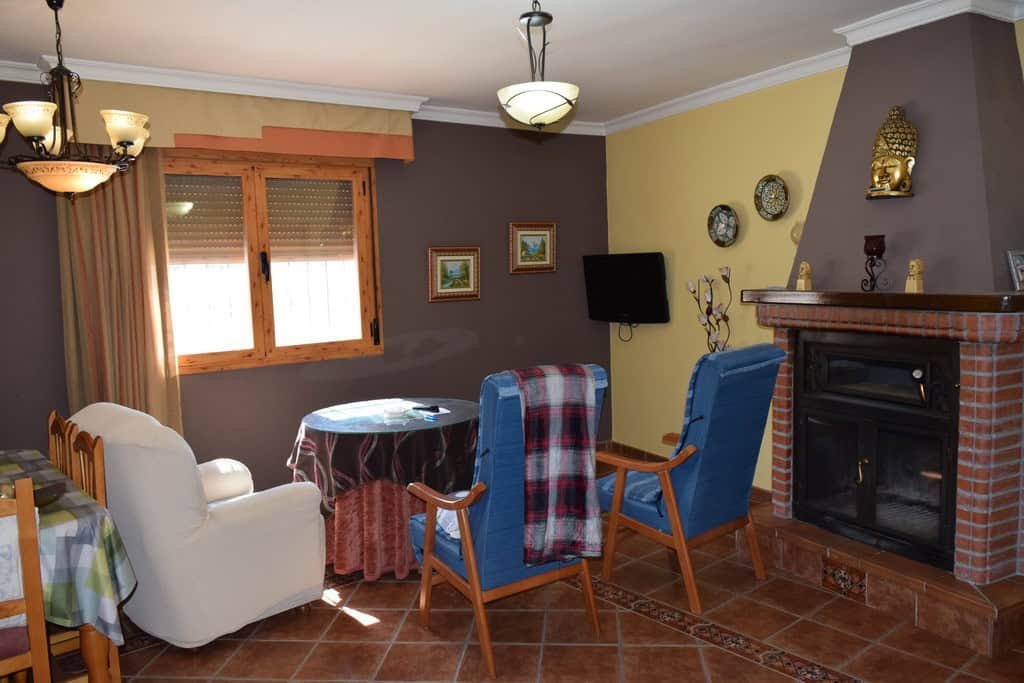 Charming cave house interior with comfortable seating, fireplace, and rustic decor in Gorafe, Granad.