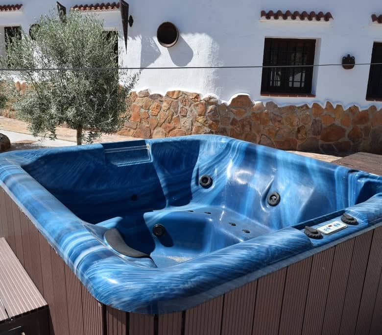 Hot tub on outdoor terrace of cave house in Cortes de Baza, Granada, offering relaxation and scenic.