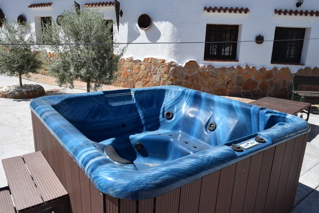 Hot tub on outdoor terrace of cave house in Cortes de Baza, Granada, offering relaxation and scenic.