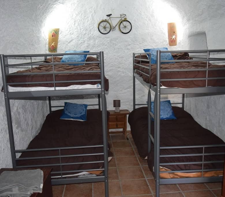 Charming cave house bedroom with bunk beds in Cortes de Baza, Granada, featuring rustic decor and un.