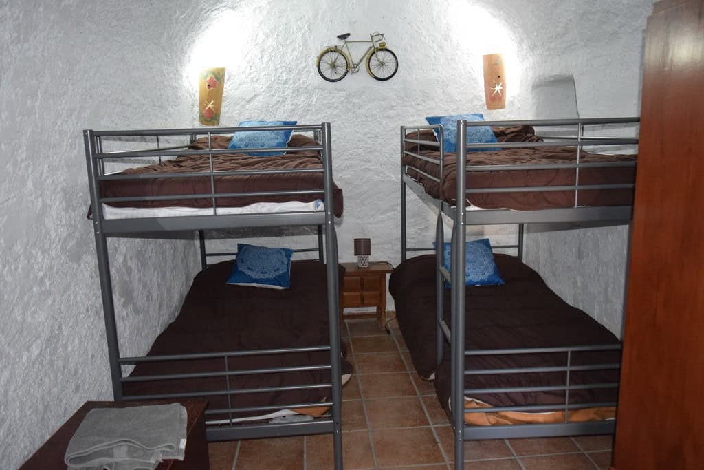 Charming cave house bedroom with bunk beds in Cortes de Baza, Granada, featuring rustic decor and un.