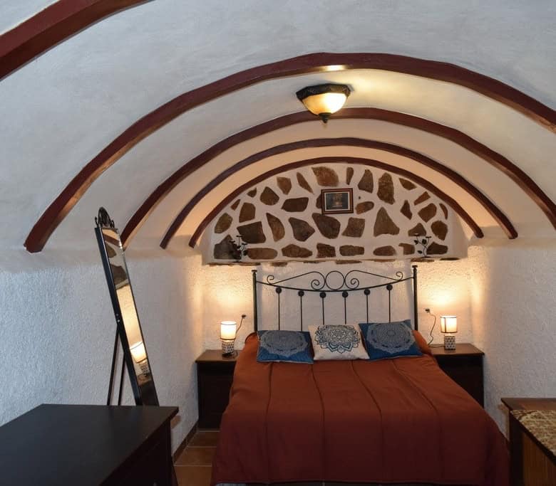 Charming cave house bedroom in Cortes de Baza, Granada with rustic stone walls and cozy interior des.