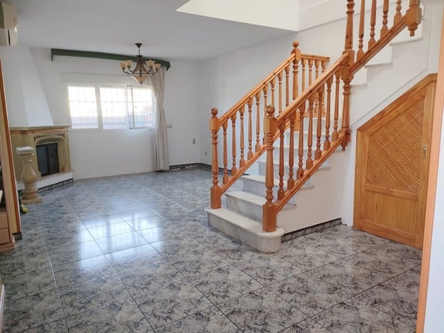 Town house interior with staircase in Fines, Almeria, Spain, featuring tiled floors and wooden accen.