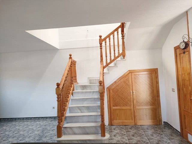 Charming town house staircase in Fines, Almeria with wooden railings and white marble steps.