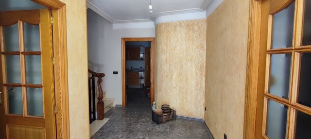 Interior view of a town house in Tijola, Almeria, showcasing a hallway with wooden door frames and t.