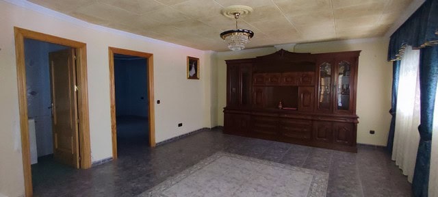 Spacious living room in a traditional Tijola town house with vintage wooden furniture and natural li.