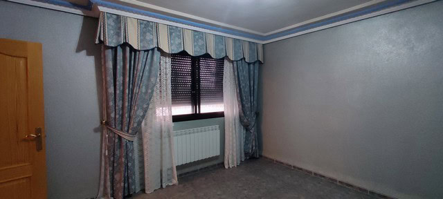 Spacious living room with large window and elegant curtains in Tijola, Almeria.