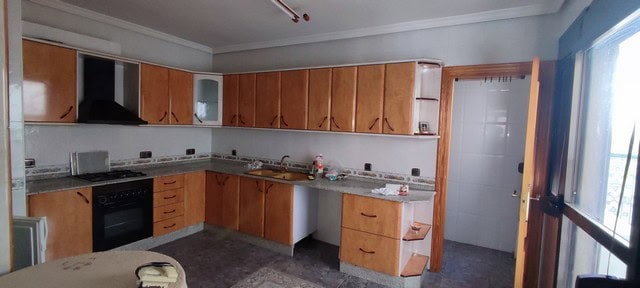 Spacious kitchen in Tijola town house with wooden cabinets and modern appliances.
