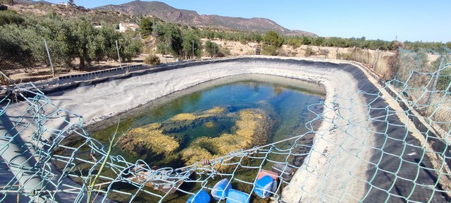 Traditional rural water reservoir in Urracal, Almeria, surrounded by scenic mountains and countrysid.