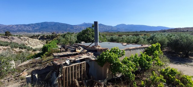 Charming rural property with scenic views in Urracal, Almeria, featuring a rustic building surrounde.