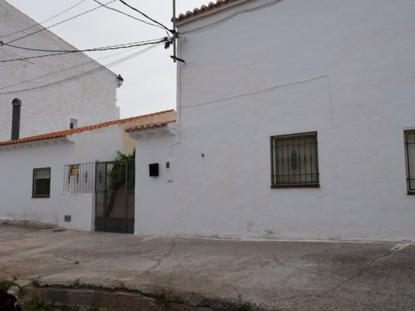 Cave house in Bacor, Granada with whitewashed walls and small windows.