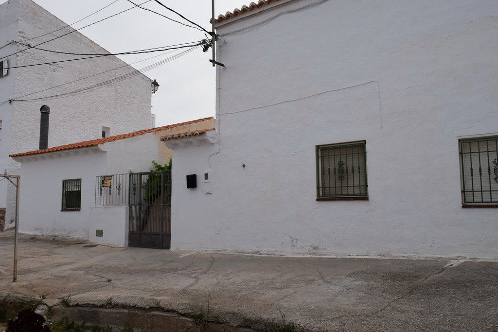 Cave house in Bacor, Granada with whitewashed walls and small windows.