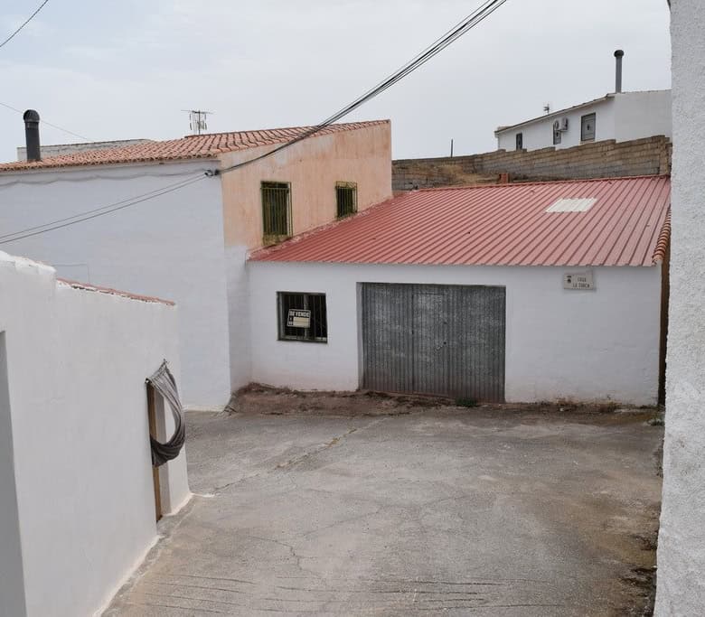 Cave house in Bacor, Granada with white walls and red roof, traditional rural property.