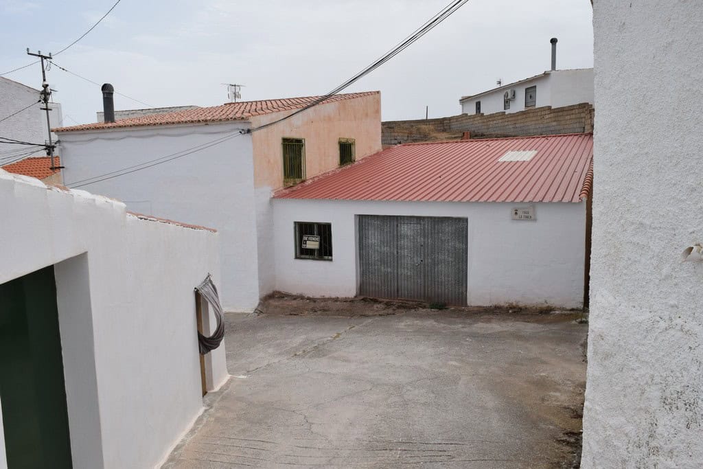 Cave house in Bacor, Granada with white walls and red roof, traditional rural property.