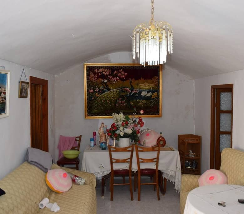 Interior view of a traditional cave house in Bacor, Granada, featuring cozy seating and decorative a.