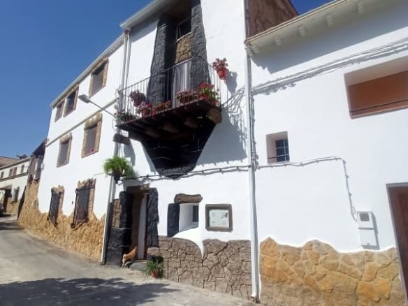 Charming village house in Fontanar, Jaen with a small balcony and traditional stone accents. Perfect.